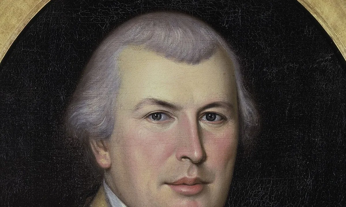 Portrait of a round-faced officer in a blue and buff uniform with gold epaulettes.