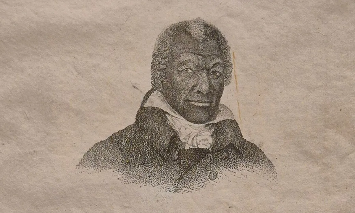 Portrait of a Black man in a dark coat and white cravat against a plain background.