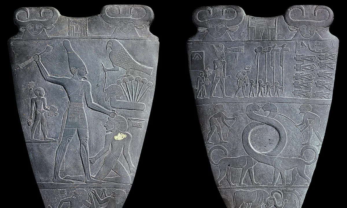 Two faces of a dark stone slab: on one a tall king raises a mace over a kneeling captive; on the other, processions of figures above two long-necked beasts.