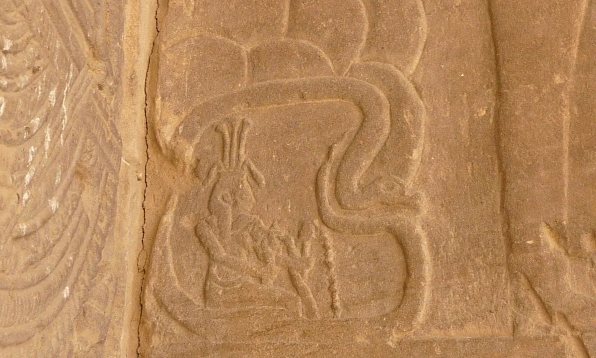 Carved relief of a seated figure inside an outline of rocks encircled by a snake, pouring water from vessels.