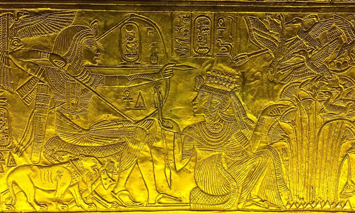 Gold relief of a seated king drawing a bow while a queen kneels beside him holding out an arrow.