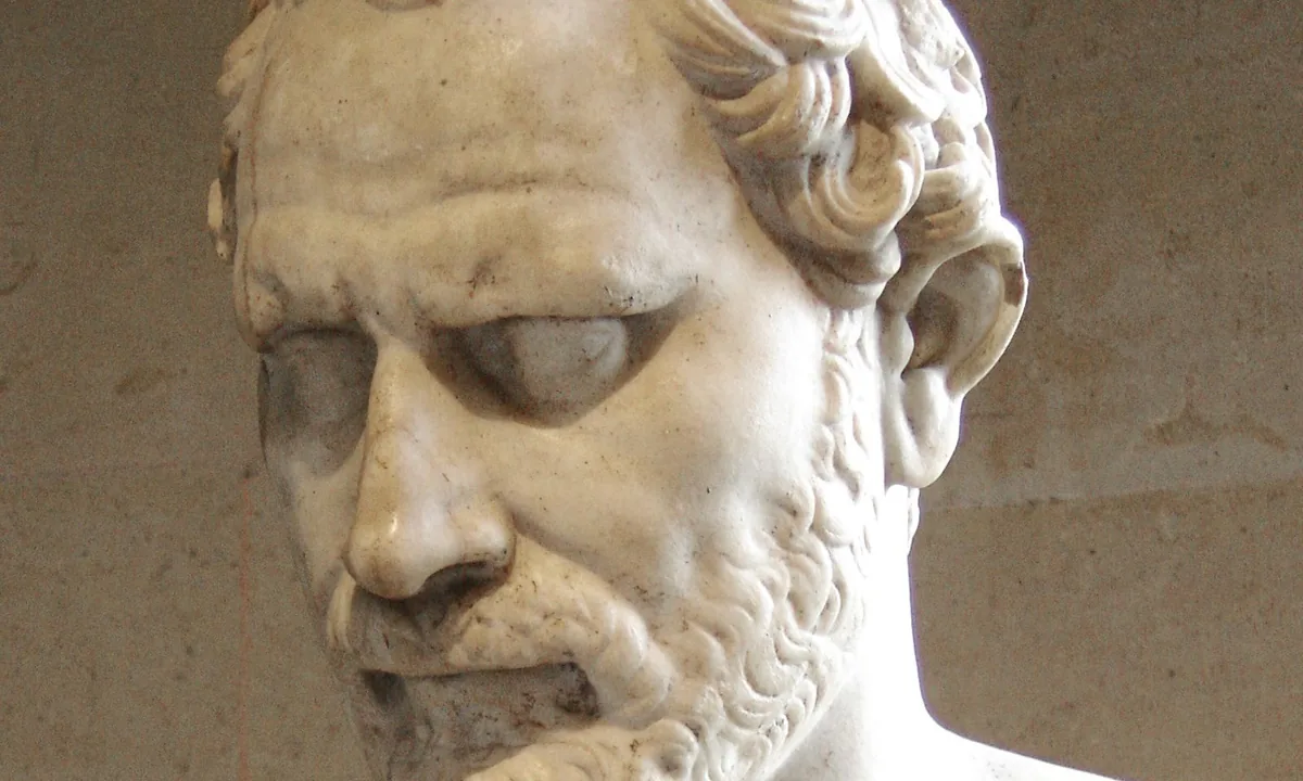 Marble bust of a frowning, bearded middle-aged man with curly hair looking down.