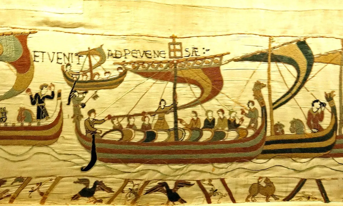 Embroidered scene of several Viking-style ships with striped sails carrying armed men and horses across stylised waves.