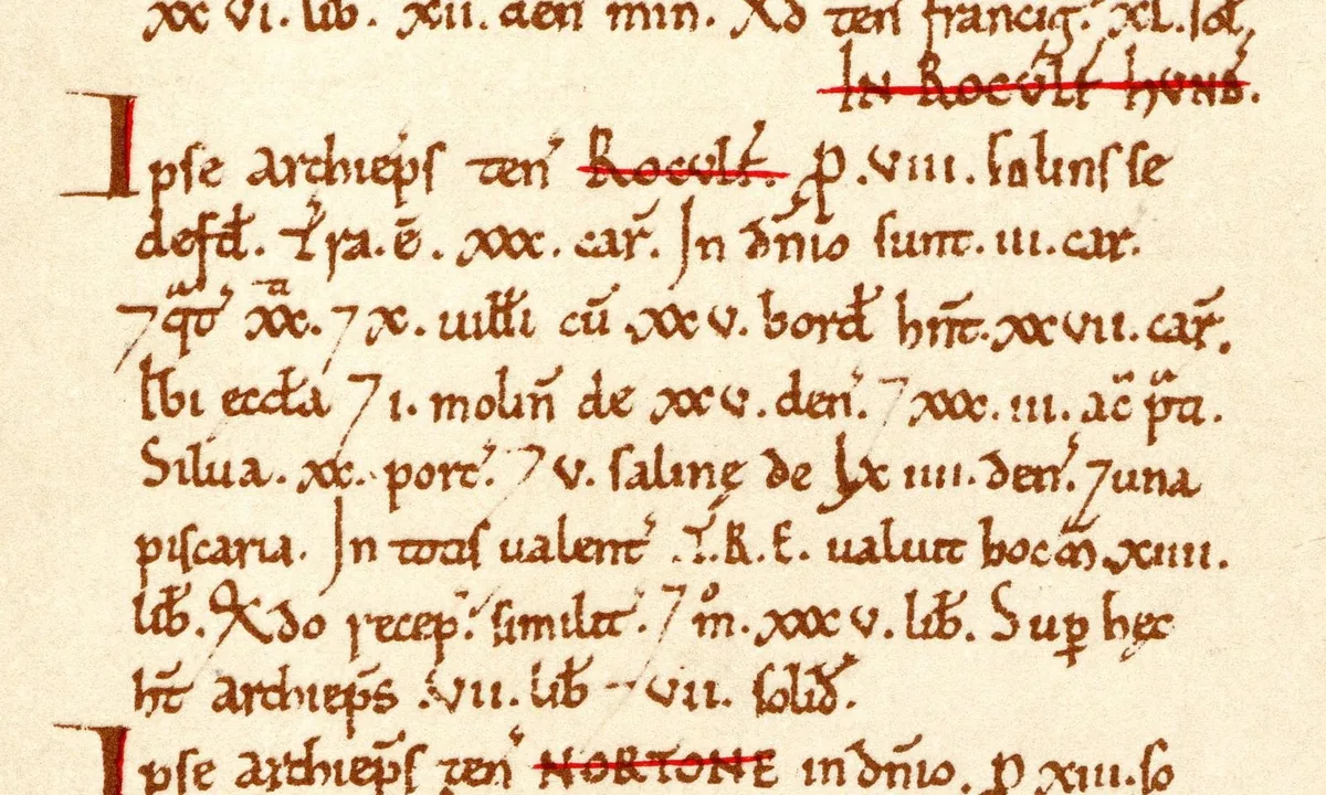Open medieval manuscript volume with dense columns of Latin script and red headings.