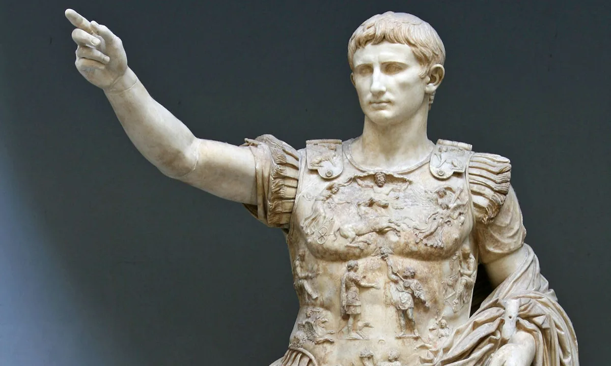 Marble statue of a young man in carved armour raising his right arm, with a small Cupid riding a dolphin by his leg.