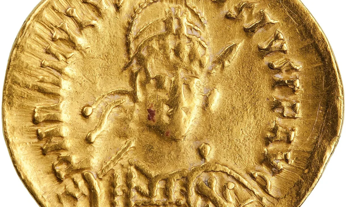 Small gold coin showing a helmeted emperor in armour holding a spear.