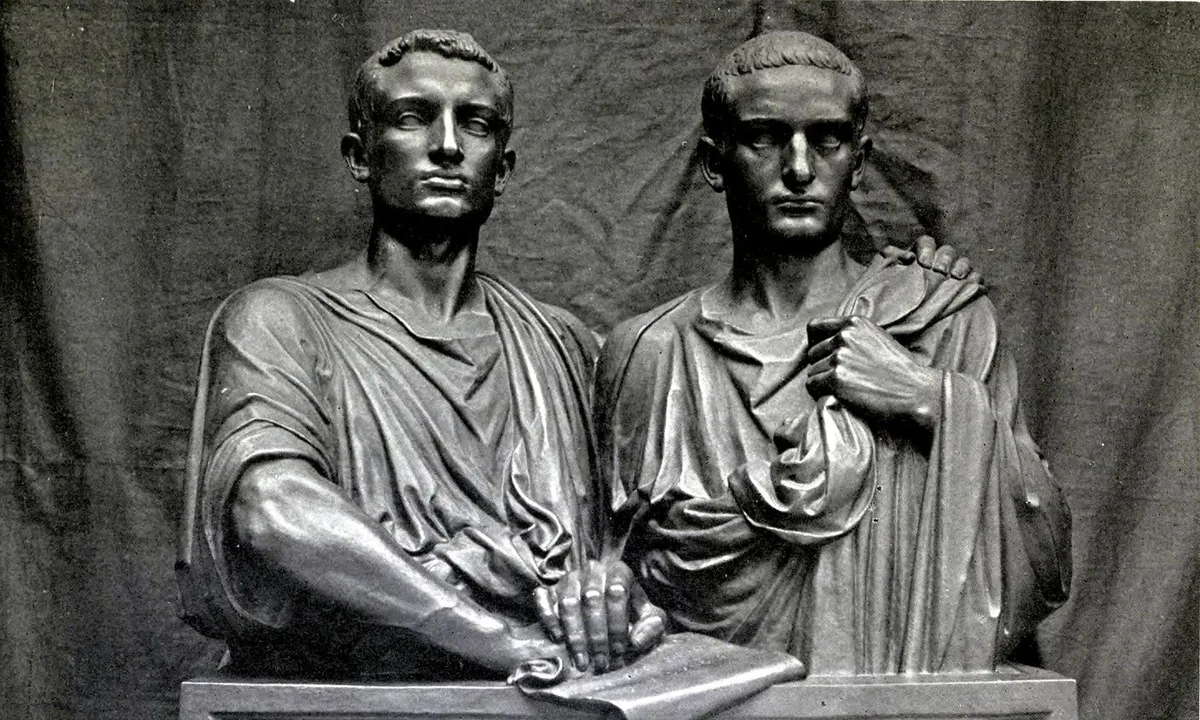 Bronze sculpture of two Roman men shown side by side from the chest up.