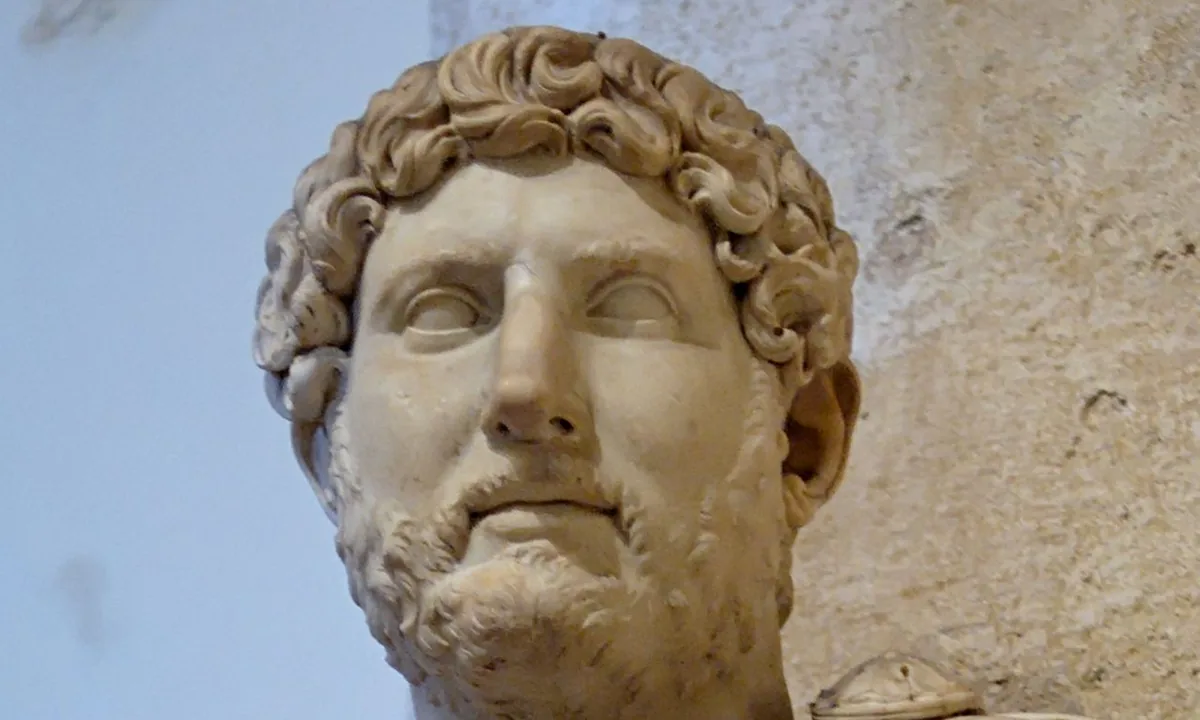 Marble bust of a bearded man with thick curly hair, wearing armour decorated with a Medusa head and a cloak knotted at the shoulder.