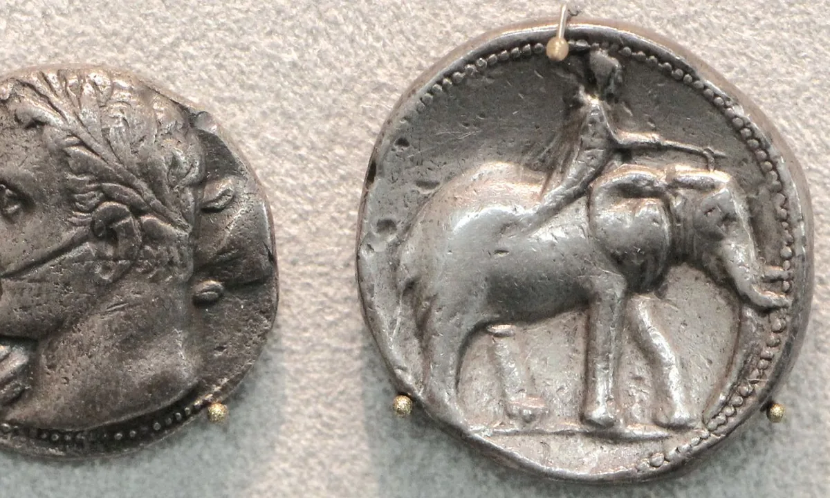 Ancient silver coin showing a walking elephant.