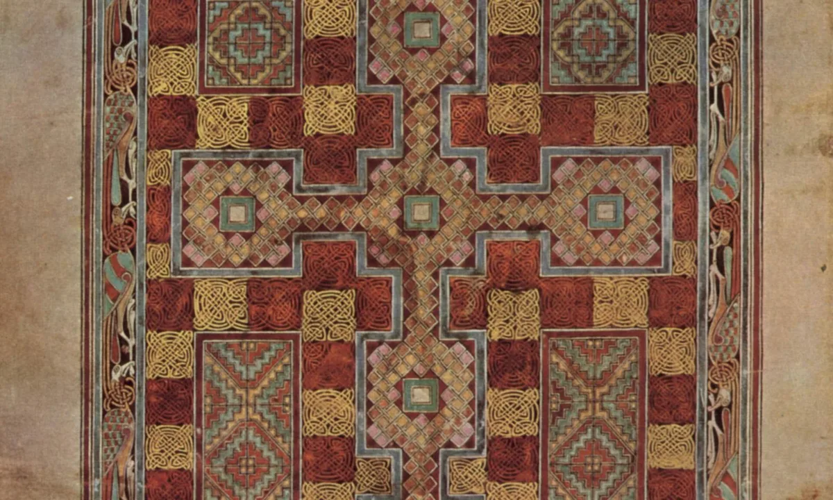Manuscript page filled with intricate interlaced patterns in red, green, blue and gold around a large cross.
