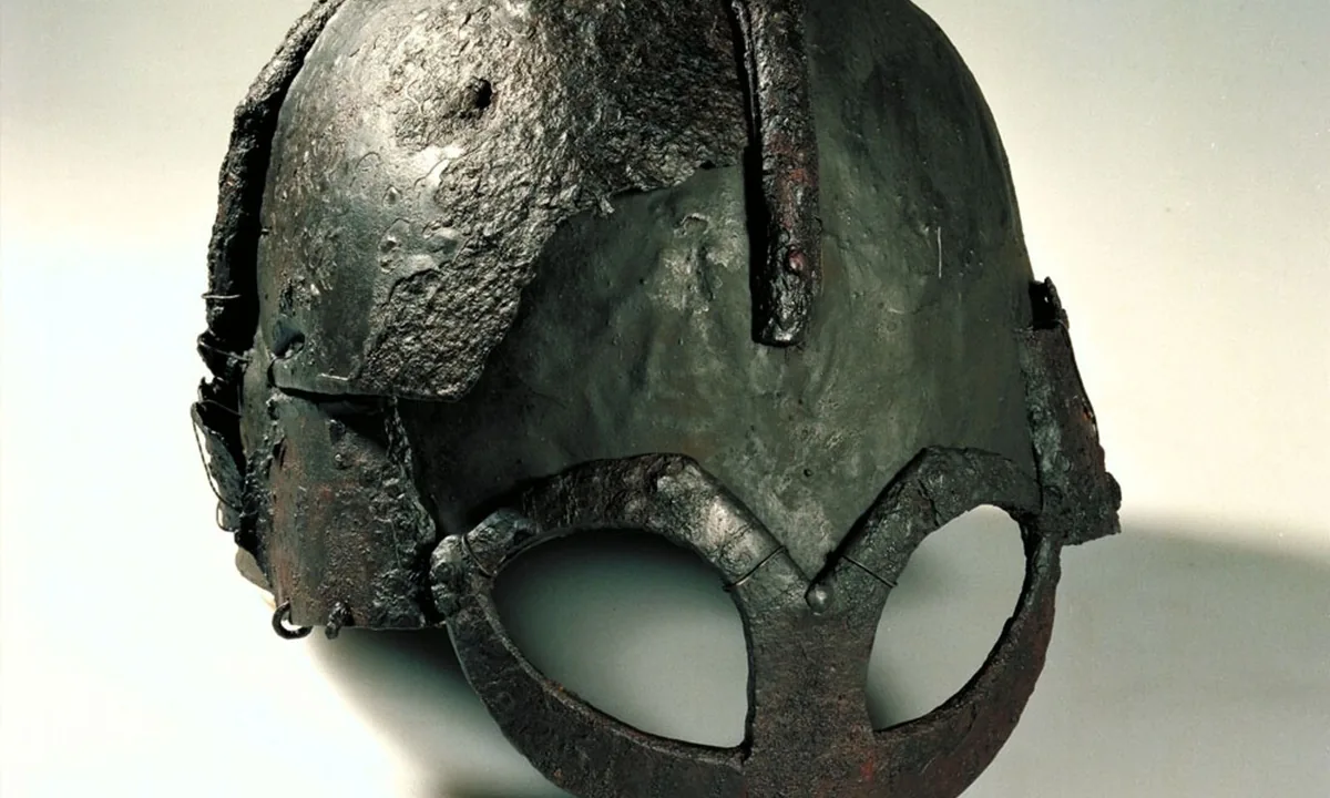 Rounded iron helmet with a spectacle-shaped guard around the eyes and nose, reconstructed from fragments.